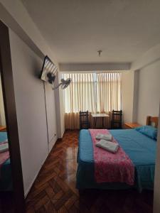 a bedroom with a bed and a lamp and a table at Hostal COSTA AZZURRA in Cerro Azul