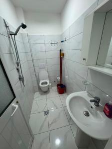 a white bathroom with a sink and a toilet at Vila Ornela in Shëngjin +19 photos