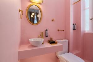 a bathroom with a sink and a toilet and a mirror at Aphrodite luxury rooms in Mytilene