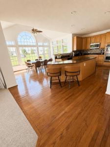 a kitchen with wooden floors and a table and chairs at 4BR Home with Private Cinema in West Henrietta