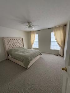a bedroom with a bed and a ceiling fan at 4BR Home with Private Cinema in West Henrietta