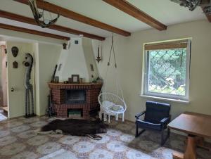 a living room with a fireplace and a chair at Czerpak in Małszewko +1 photo