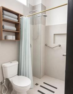 a bathroom with a toilet and a shower at Galápagos Downtown Suite in Puerto Ayora