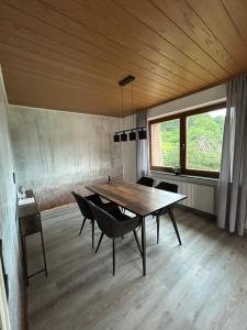 a dining room with a wooden table and chairs at Haus am Skywalk 3L in Beverungen