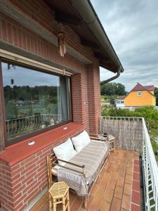 a bed on a brick porch with a window at Haus am Skywalk 3L in Beverungen