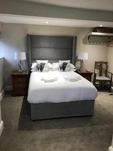 a bedroom with a large white bed with two night stands at The Bulls Head in Swadlincote