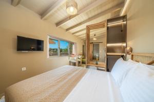 a bedroom with a large bed and a tv at Sea salt house in Zambelláta +20 photos