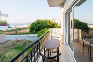 a balcony with a table and chairs and a view of the ocean at Dolphins maisonette Rhodes in Ialysos