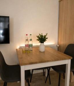 a table with three bottles and wine glasses on it at DADI Apartment in Linz am Rhein