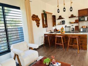 a kitchen with a counter and a bar with stools at Shubbys Villa in Dar es Salaam