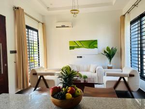 a living room with a bowl of fruit on a table at Shubbys Villa in Dar es Salaam
