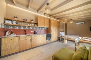 a large kitchen with wooden cabinets and a couch at Sea salt house in Zambelláta