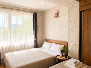a hotel room with a bed and a window at Kitesa's apartment with two bedrooms in Mtskheta