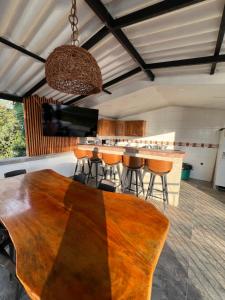 a kitchen with a wooden table and bar with stools at Tangara Real Hotel Campestre in Quimbaya