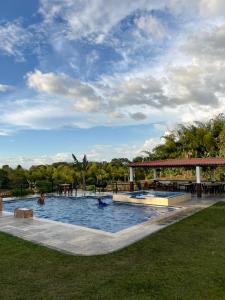 a large swimming pool with people in the water at Tangara Real Hotel Campestre in Quimbaya