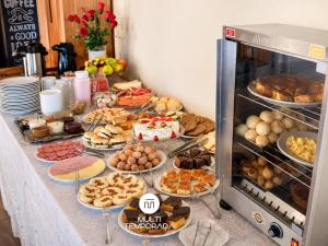 a table with many different types of pastries and food at Pousada Dona Teresinha com Piscina Aquecida - São Bonifácio/SC in São Bonifácio