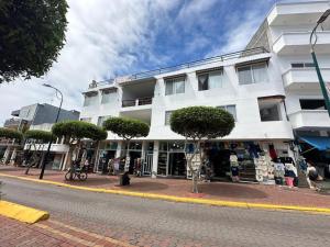 a white building on the side of a street at Galápagos Downtown Suite in Puerto Ayora