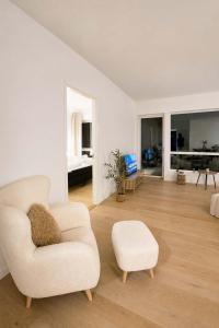 a white living room with a chair and a couch at The Nordic - 2BR in Voss - The Voss Collection in Vossevangen
