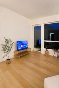 a living room with a flat screen tv and a wooden floor at The Nordic - 2BR in Voss - The Voss Collection in Vossevangen