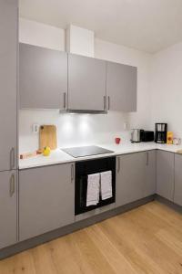 a kitchen with white cabinets and a stove top oven at The Nordic - 2BR in Voss - The Voss Collection in Vossevangen +13 photos
