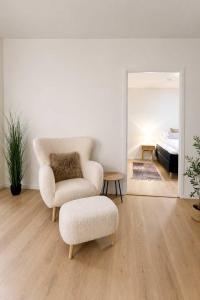 a living room with a chair and a ottoman and a bedroom at The Nordic - 2BR in Voss - The Voss Collection in Vossevangen