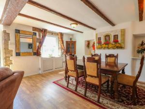 a dining room with a wooden table and chairs at Jasmine Cottage in Matlock