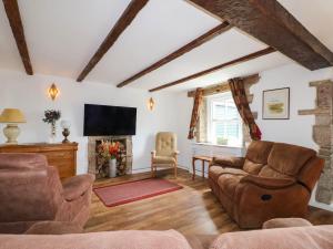 a living room with a couch and a fireplace at Jasmine Cottage in Matlock