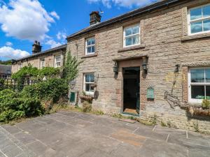 an old brick house with a driveway in front of it at Jasmine Cottage in Matlock