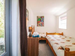 two beds in a room with a window at Jasmine Cottage in Matlock