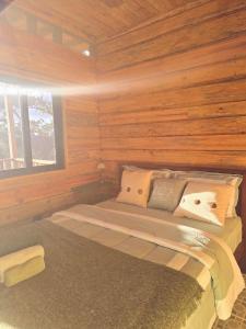 a bedroom with a bed in a wooden cabin at Altos del Dragón in Valle de Anton