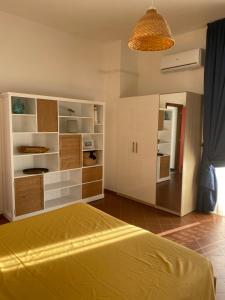 a bedroom with a yellow bed and a large cabinet at Hotel e Residence Il Faro Acciaroli in Acciaroli