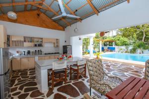 an open kitchen and dining room with a pool at Diani Luxe Villa in Mombasa