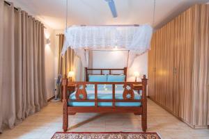 a bedroom with a bed with a canopy at Diani Luxe Villa in Mombasa