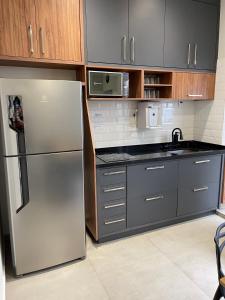 a kitchen with a stainless steel refrigerator and cabinets at Hostel Mirandopólis in São Paulo