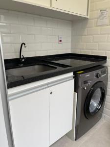 a kitchen with a sink and a washing machine at Hostel Mirandopólis in São Paulo