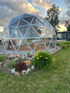 a large glass greenhouse in a garden at Poilsio oazė Stebuliuose in Stebuliai