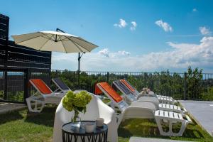a group of lawn chairs and an umbrella at Casa Kapela in Donji Koncovčak