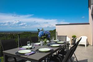 a table with glasses and flowers on a balcony at Casa Kapela in Donji Koncovčak