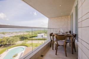 a balcony with a table and chairs and a pool at Modern apt with 2 BR BBQ and views in Cartagena de Indias
