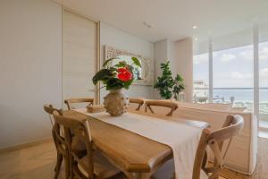 a dining room with a table and a vase with a flower on it at Modern apt with 2 BR BBQ and views in Cartagena de Indias
