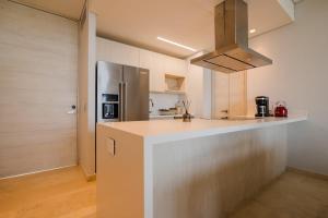 a kitchen with a counter top and a refrigerator at Modern apt with 2 BR BBQ and views in Cartagena de Indias +38 photos
