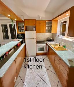 a kitchen with wooden cabinets and a white refrigerator at Aronis Spyros Panoramic Seaview Apartments in Longós