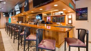 a bar with a row of bar stools in a restaurant at Best Western Tomah Hotel in Tomah