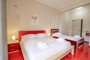 two beds in a room with red and white at Blue Stay Boutique Hotel in Himare