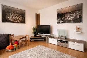 a living room with a television and a table at Ferienwohnung Schaftnach Rednitzblick nähe Messe in Schwabach