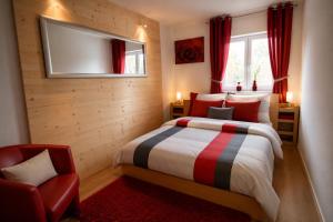 a bedroom with a bed and a tv and a chair at Ferienwohnung Schaftnach Rednitzblick nähe Messe in Schwabach