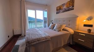 a bedroom with a bed and a large window at Luxury Ría Noia in Noya