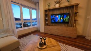 a living room with a couch and a tv at Luxury Ría Noia in Noya