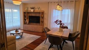 a living room with a dining table and a tv at Luxury Ría Noia in Noya