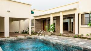 a house with a swimming pool in front of a house at Villas HouN Assinie in Mafia